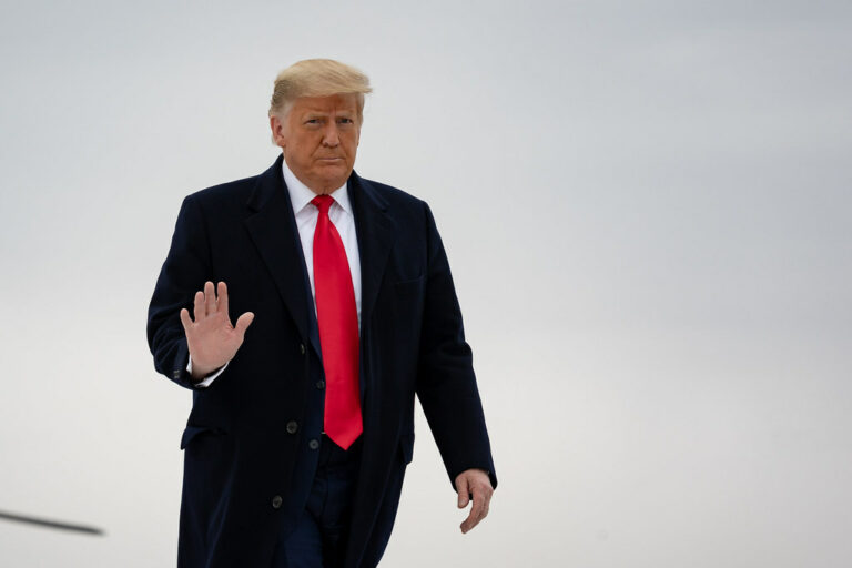 President Donald Trump waves while walking to board a helicopter.