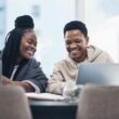 Two people sitting behind a computer